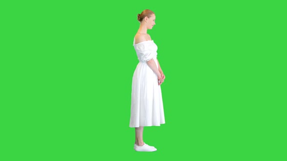 Beautiful Woman in White Dress Posing To Camera on a Green Screen Chroma Key