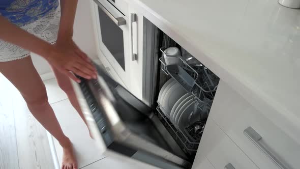 Woman Taking Out Plates From Dishwasher