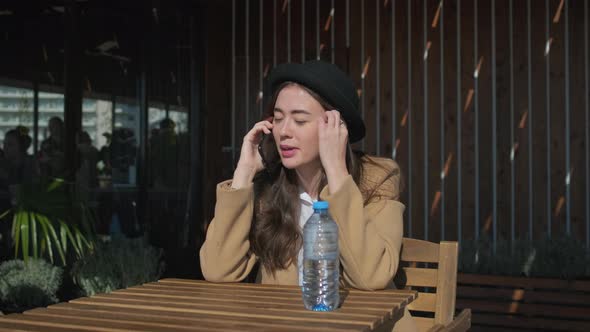 Pretty Adolescent Girl Is Answering on Mobile Call in Open Terrace of Cafeteria