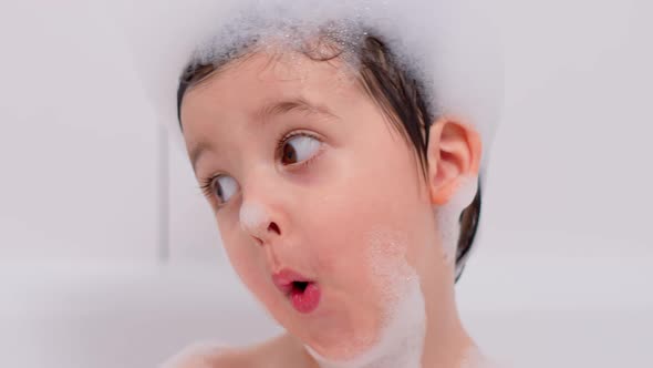 Three Year Old Child with Big Brown Eyes Is Sitting in a White Bathroom