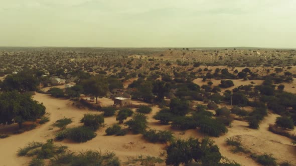 Aerial View Over Tharparkar With Rural Huts On The Ground. Dolly Forward, Tilt Down