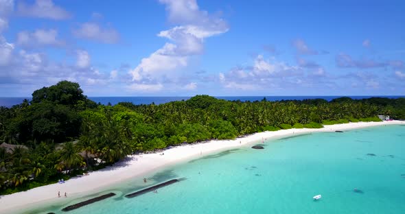 Wide fly over island view of a sandy white paradise beach and aqua turquoise water background in col