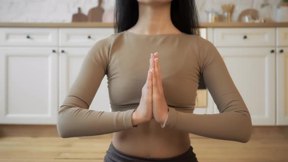 Relaxed Young Woman in Sportswear Is Meditating in Lotus Position