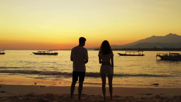 Romantic couple in love on paradise coastline beach wildlife by blue sea with white sand background 