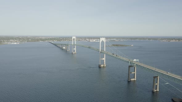Drone shot of a big bridge that crosses the water,ing forward and slowly tilting down.