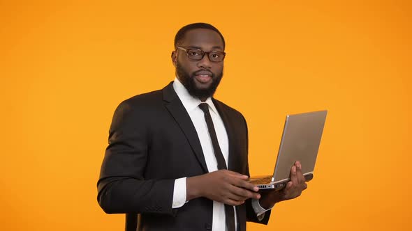 Joyful Afro-American Businessman Holding Laptop and Showing Ok Sign, Success