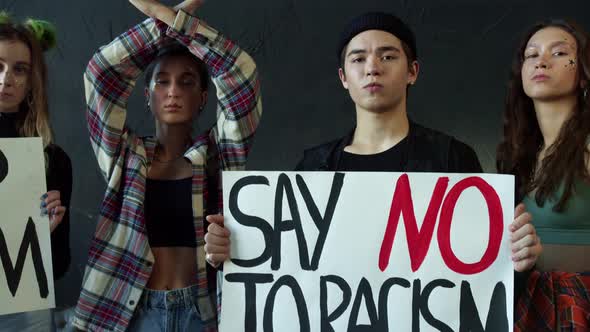 Young Girls and a Guy Holding Banners for Awareness Campaign Against Racial Discrimination