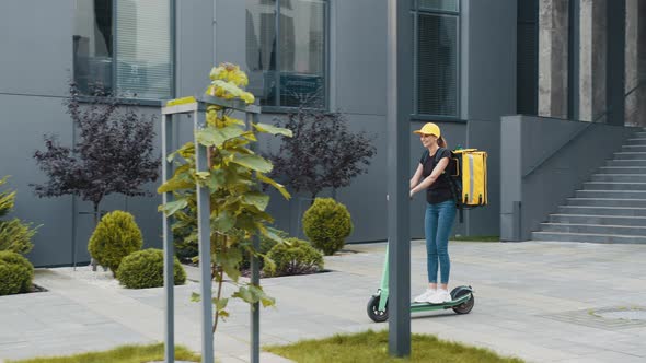 Delivery Service Woman Riding Scooter in Big Modern City