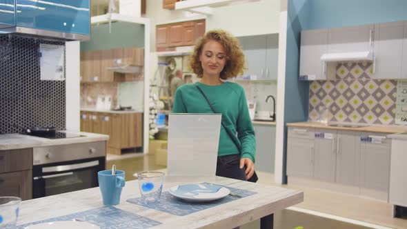 Young Woman Housewife Choosing Kitchen Furniture To Buy in Store