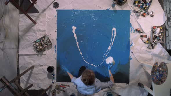 The Artist for the Drawing Pours White Paint on Blue