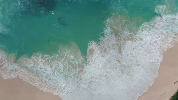 Slow Motion Top View of Sea Foamy Splashing Waves on a White Sand Beach