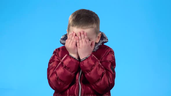 Boy Acting Like Afraid, Hiding, Closing His Face with Hands