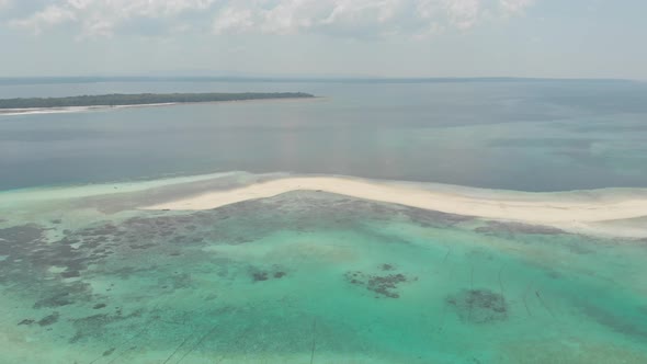 Aerial: tropical beach island reef caribbean sea white sand bar Snake Island, Indonesia Maluku