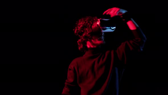 Man with VR Helmet on His Head Dances in Redblue Lights Online Party