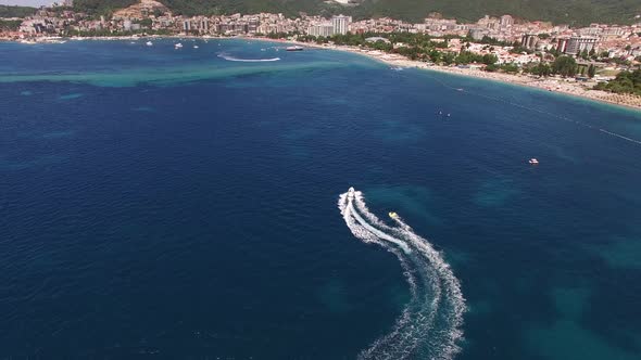 Drone View of a Motor Boat Sailing on the Sea to the Coast of Budva