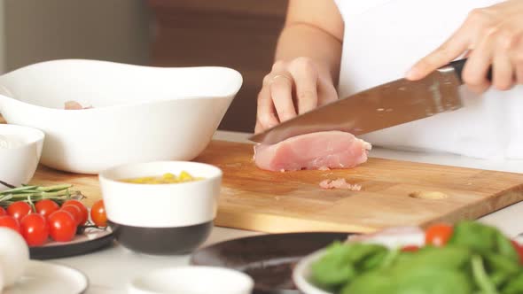 Pleasant Young Woman Preparing Dinner in a Kitchen Concept Cooking