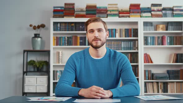 Serious male blogger recording training and coaching via webcam at home