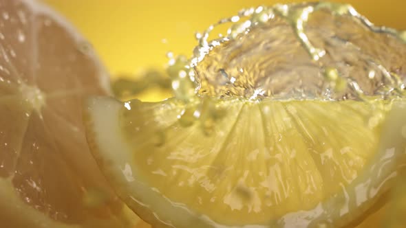 Slow Motion Shot of Lemon Juice Splashing Through Lemon Slices