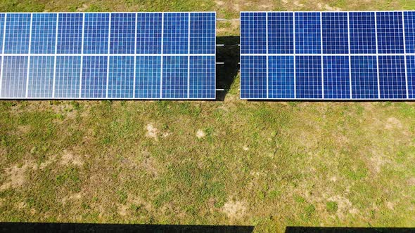 Flight over blue solar panels standing on the ground.