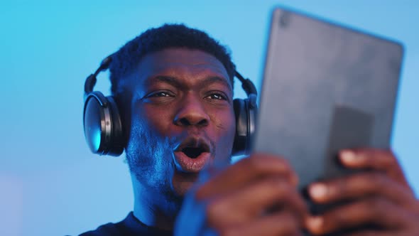 Guy Wearing Headphones and Holding a Tablet Watching Video  Intense Expressions