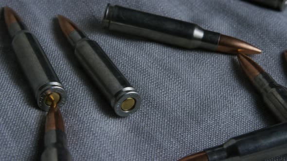 Cinematic rotating shot of bullets on a fabric surface - BULLETS 106