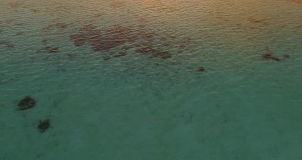 Aerial drone view of a man and woman having dinner on a floating raft boat at sunset