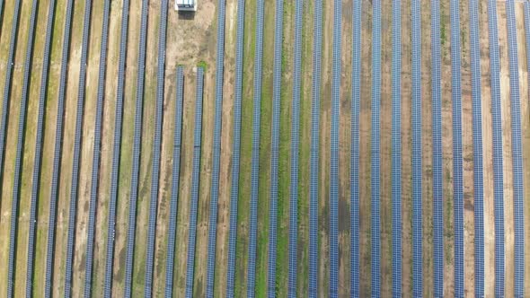 Aerial Top View on Solar Power Station in Green Field on Sunny Day. Solar Farm