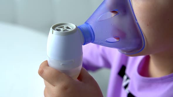 Close Up View of Inhaler Mask When Little Girl Makes Inhalation with Medical Nebulizer