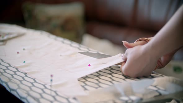 Young Woman Seamstress Cutting the Cloth Following the Soap Marks