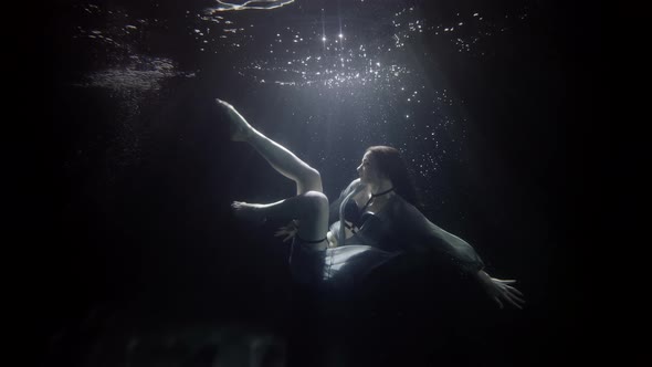 Underwater Magic Young Fragile Woman Is Floating in Dark Depth Moving Slowly