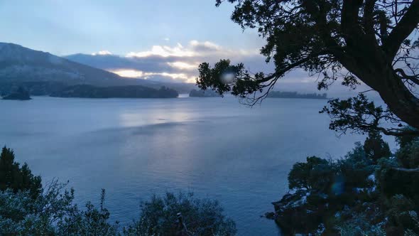 Time lapse video of beautiful patagonia lake after sunset. Steady cam shot taken from behind a tree.