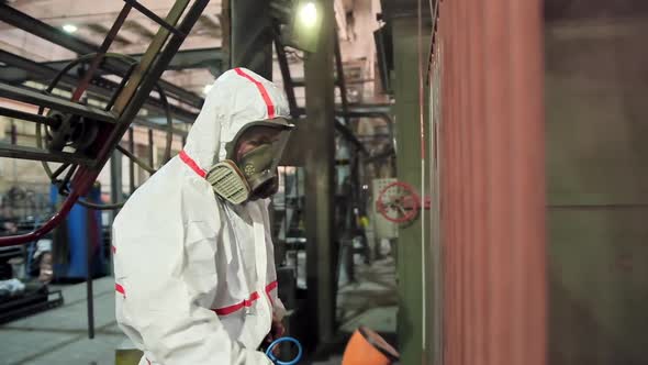 Man holding powder coating sprayer. Worker painting metal products with a spray gun