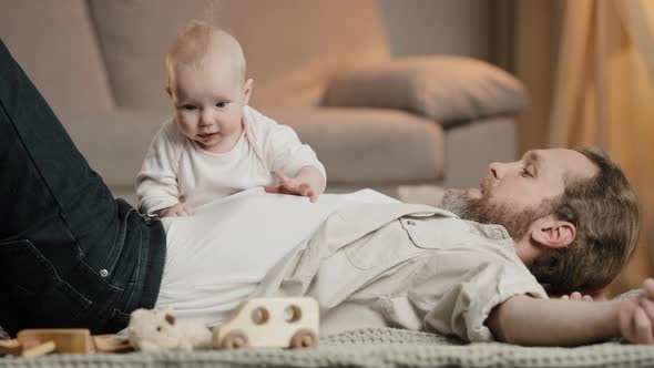 Caucasian Family Father with Little Daughter Son Lie on Floor at Home Play
