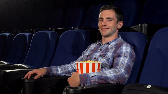 Happy Handsome Man Smiling Joyfully Sitting at the Cinema