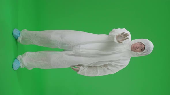 Full Body Of Asian Man Wear Protective Uniform Ppe And Showing Hand Stop Sign In Green Screen Studio