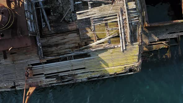 A Wrecked Wooden Ship Lies on the Seashore Covered with Rust