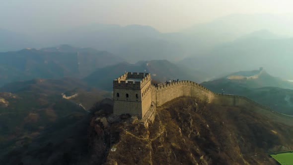 Great Wall of China and Green Mountains in Smog at Sunset. Badaling. Aerial View