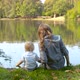 Mother and her toddler are feeding the ducks on a lake - VideoHive Item for Sale