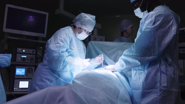 Female surgeon closing up incision