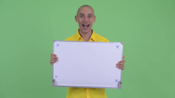 Happy Handsome Bald Businessman Holding White Board and Looking Surprised