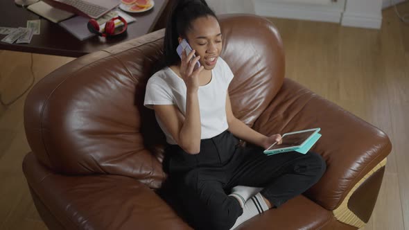 High Angle View of Confident Expert Sitting on Cozy Armchair in Home Office Talking on the Phone