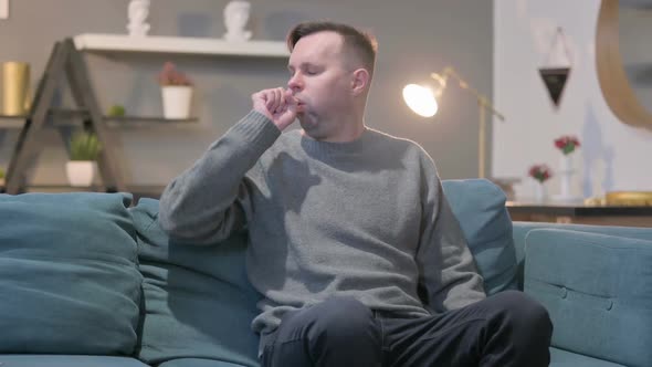 Casual Man Coughing While Sitting on Sofa