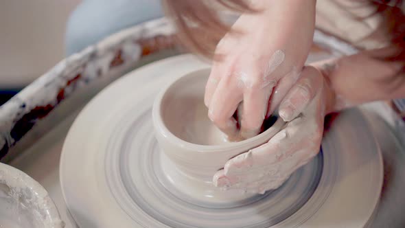 Ceramist Sculpting Clay Mug on a Wheel.