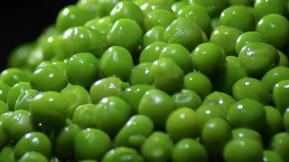 Fresh green peas on black background gyrating