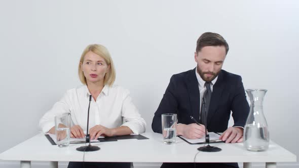 Businesswoman Holding Press Conference with Male Colleague