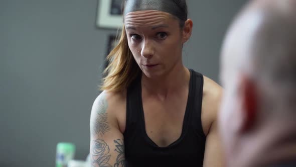 Concerned female athlete consulting with her physiotherapist in office