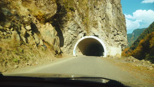 car drives through mountain tunnel. first-person driver drives car
