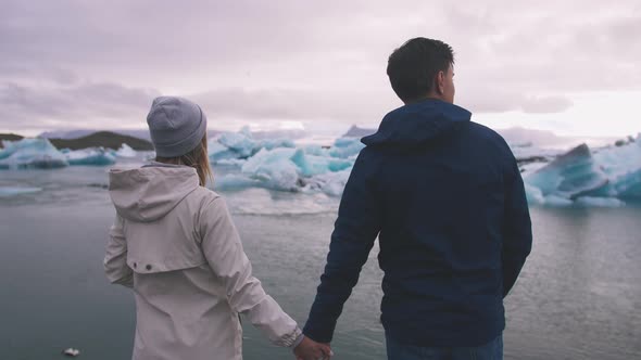 Young Couple Looking at Jokulsarlon Glacier Lake in Iceland Cinematic Shot