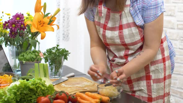 Woman In Kitchen Following Recipe On Digital Tablet