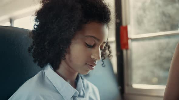 African American Schoolgirl Looking Camera in School Bus Close Up